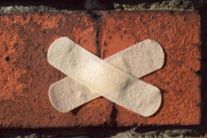 An image of a bandage on a brick wall, symbolizing the question of if visualization groups can help treat addiction 