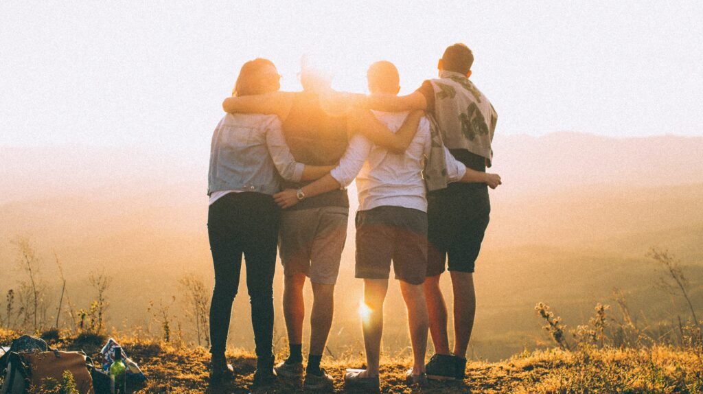 A group of people stand with their arms around each other to represent Gratitude Lodge's drug and alcohol addiction treatment program in California.