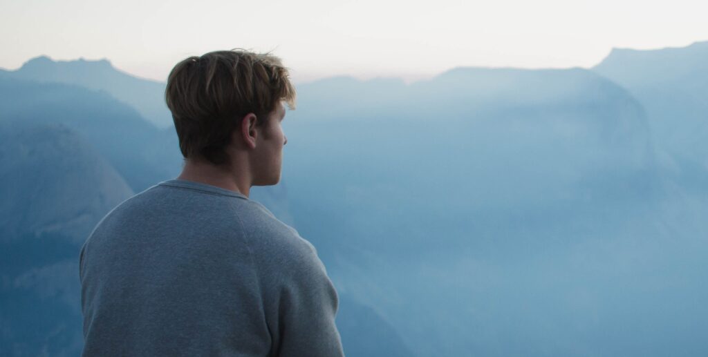 A man looks out at mountains representing how to get sober from alcohol.