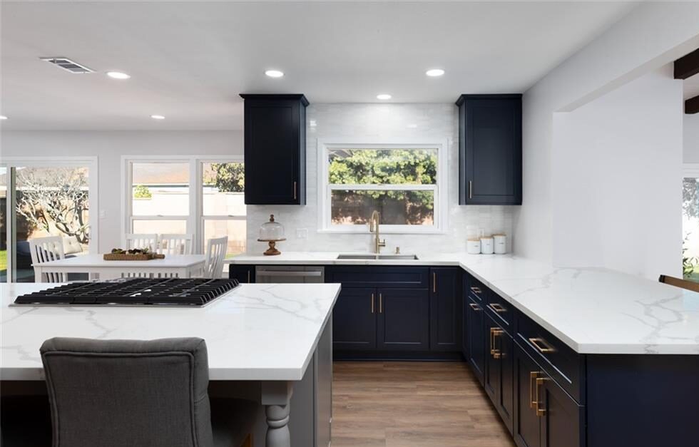 Image of a kitchen with white counters and black cabinets