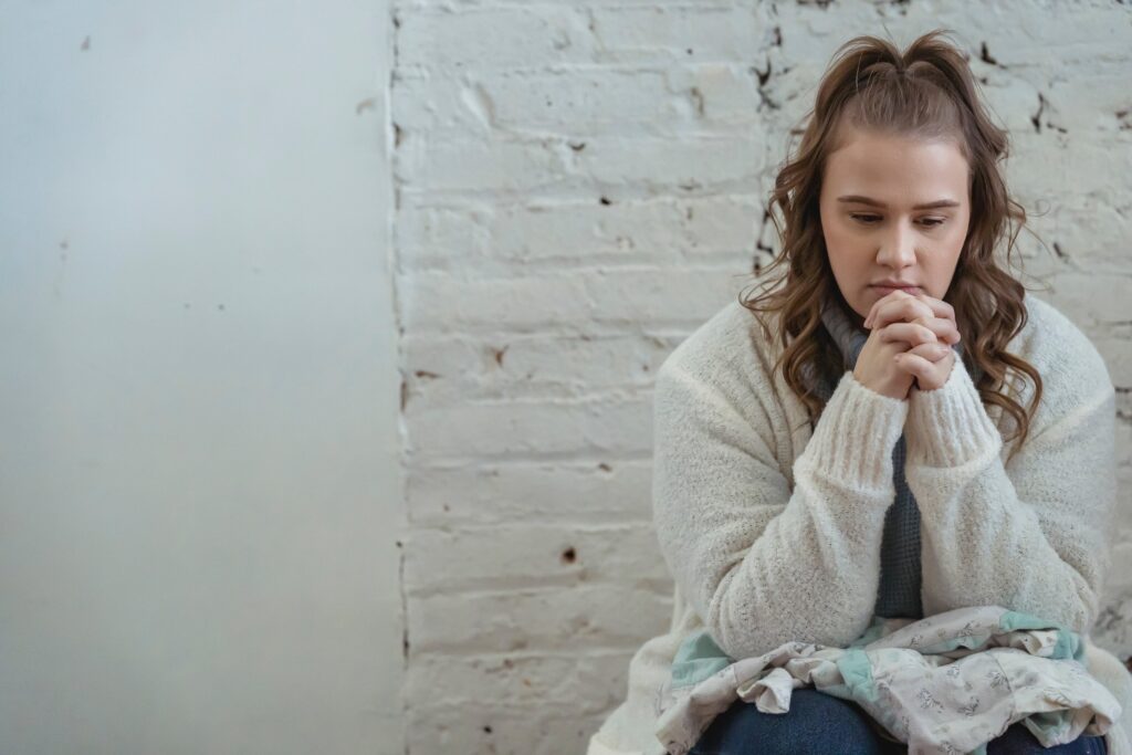 A woman sits an contemplates prednisone addiction