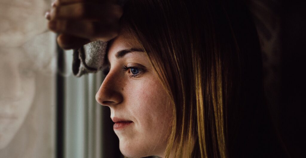 woman looks out window representing timeline for fentanyl withdrawal