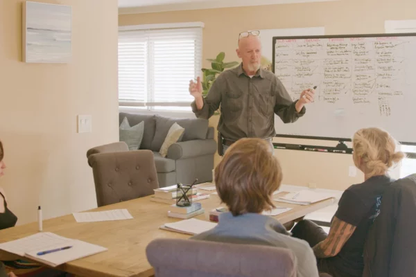 An image of a man speaking with team members about the benefits of rehab services